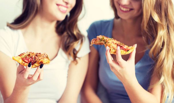 happy friends or teen girls eating pizza at home - Foto, immagini