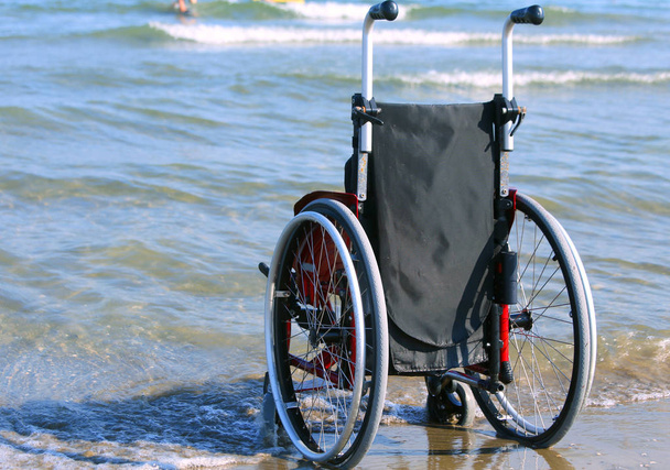 Інвалідне крісло на березі моря в спекотний сонячний літній день
 - Фото, зображення