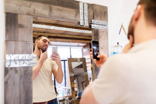 man taking selfie by smartphone at barbershop - Фото, зображення
