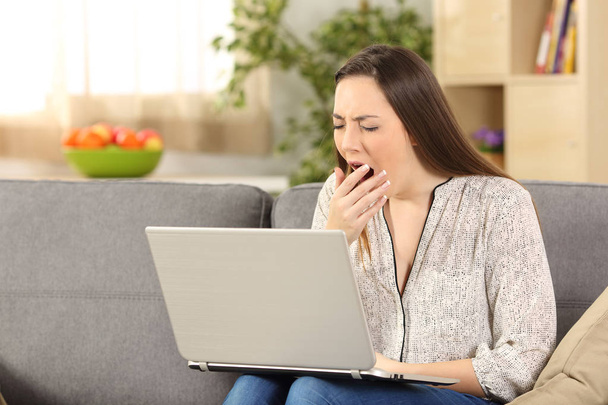 Bored woman on line yawning at home - Photo, image