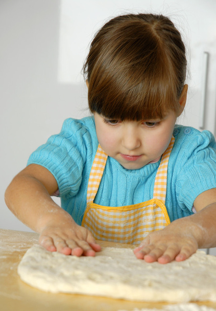 Little girl cooking a pizza in a kitchen.Little kid in a kitchen. - Foto, imagen