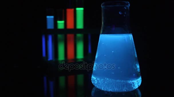 Tıbbi test tüpleri ve şişesi içinde parlayan sıvı kimyasallar. - Video, Çekim