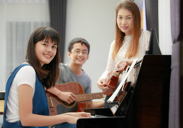 Азиатская семья играет вместе музыку
 - Фото, изображение