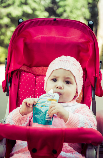 Το μωρό τρώει ένα πουρέ από ένα σούπερ μάρκετ - Φωτογραφία, εικόνα