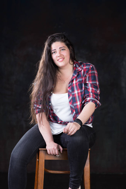 Beautiful plus size model with a dark long hair in a casual outfit - Photo, Image