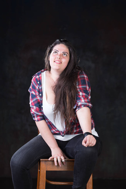 Beautiful plus size model with a dark long hair in a casual outfit - Fotó, kép