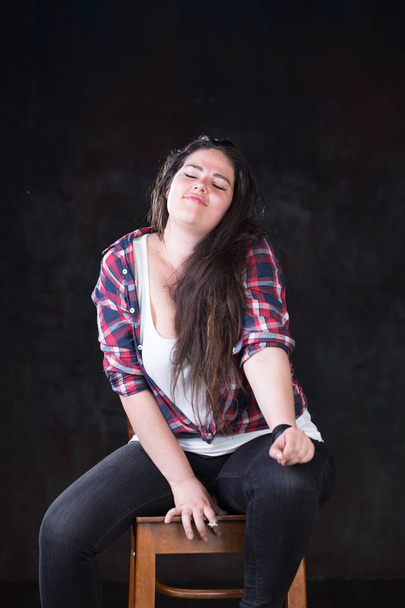 Beautiful plus size model with a dark long hair in a casual outfit - Foto, Imagen