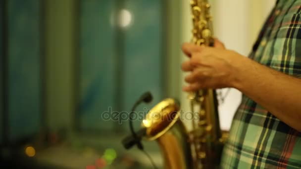 O saxofonista toca saxofone. Um close-up do saxofone
 - Filmagem, Vídeo
