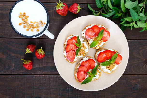 Mini sandwichs au fromage cottage, fraises fraîches, décorés de feuilles de menthe
 - Photo, image