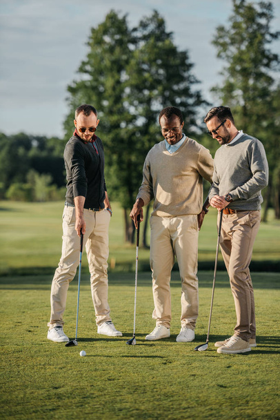 amici multietnici giocare a golf
  - Foto, immagini