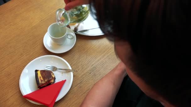A man in a cafe enjoys ice tea and pie  - Záběry, video