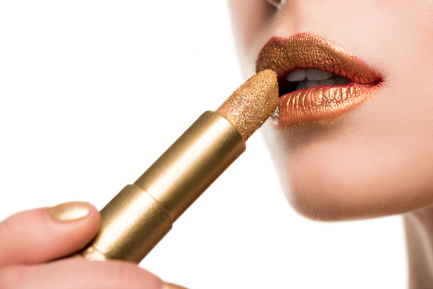 woman applying golden lipstick - Фото, изображение
