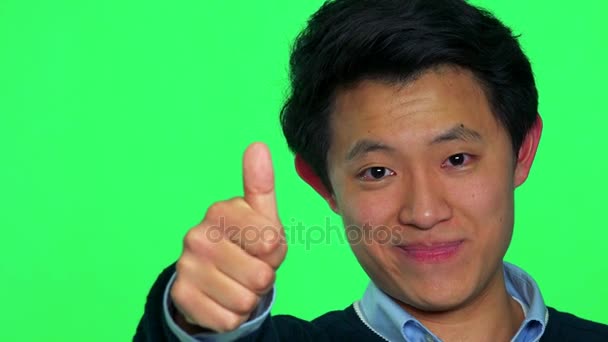 Ázsiai férfi mosolyog, és felbukkan egy hüvelykujj - Felvétel, videó
