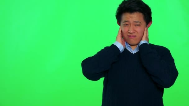 man covers his ears and grimaces against a loud sound  - Footage, Video