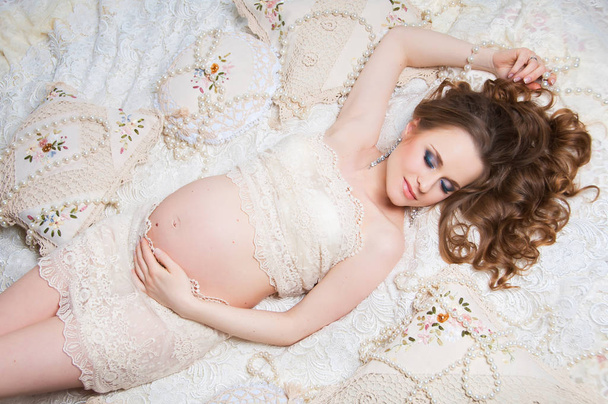 Beautiful pregnant woman with luxurious hair black lying on the couch. Top view - Valokuva, kuva