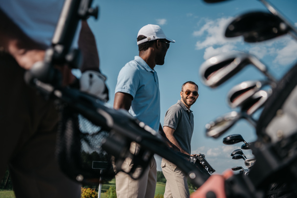 jugadores sonrientes que van al campo de golf
 - Foto, Imagen