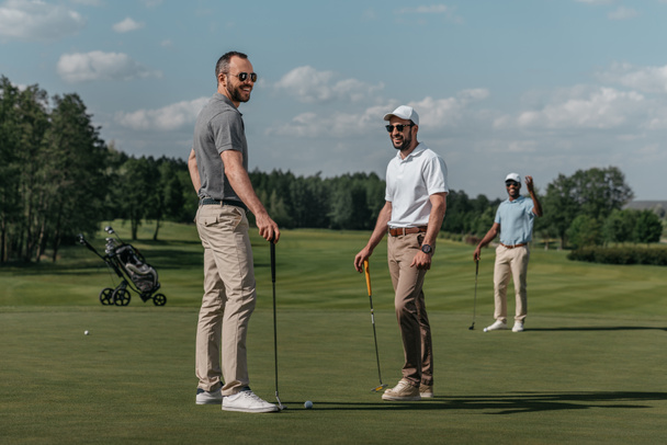 smiling friends playing golf - Photo, Image