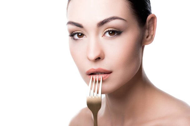 young woman pressing fork to lips - 写真・画像