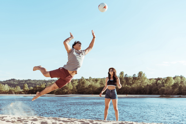 Vrienden spelen volleybal op zandstrand - Foto, afbeelding