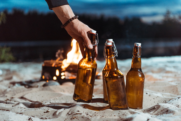 human hand taking bottle of beer - Фото, изображение