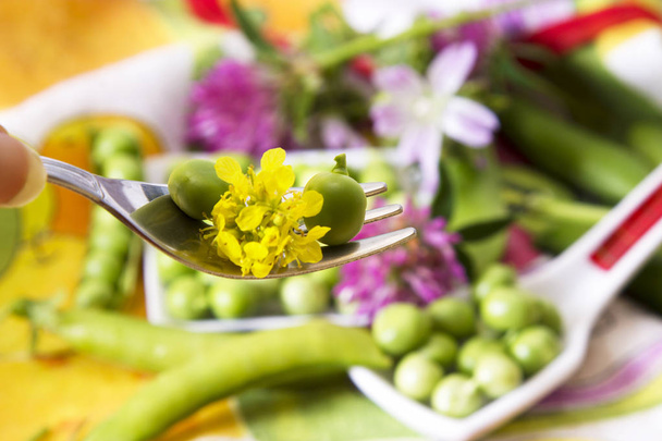 Spoon of green peas on colorful tablecloth - Photo, Image