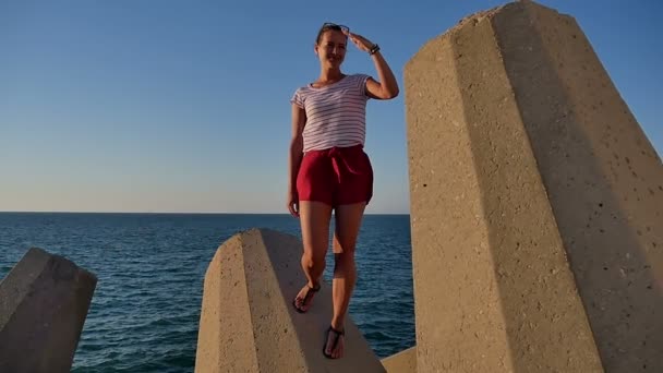 lächelndes Mädchen, das auf Blöcken steht und auf lustige Weise salutiert - Filmmaterial, Video