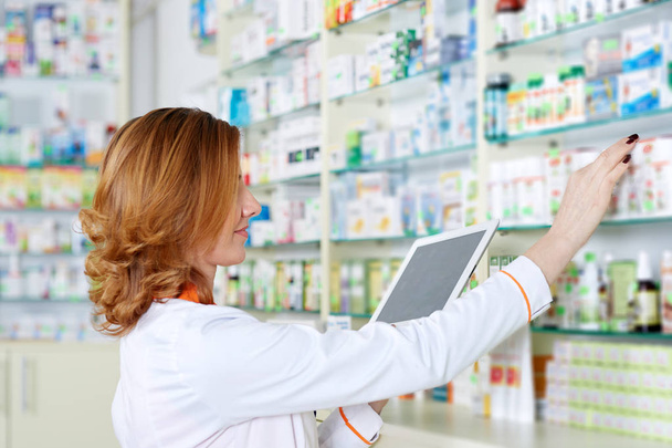 Pharmacist checking her stock of medicine  - Foto, Imagem