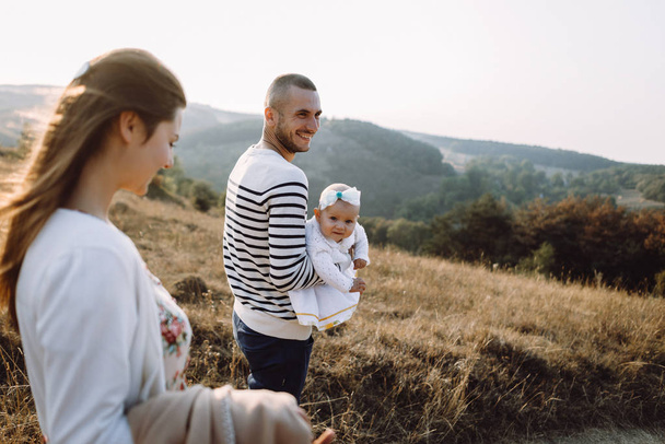 Jong gezin met dochter wandelen in de bergen - Foto, afbeelding