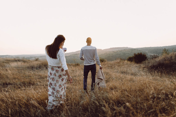 Молодая семья с дочерью, гуляющей в горах
 - Фото, изображение