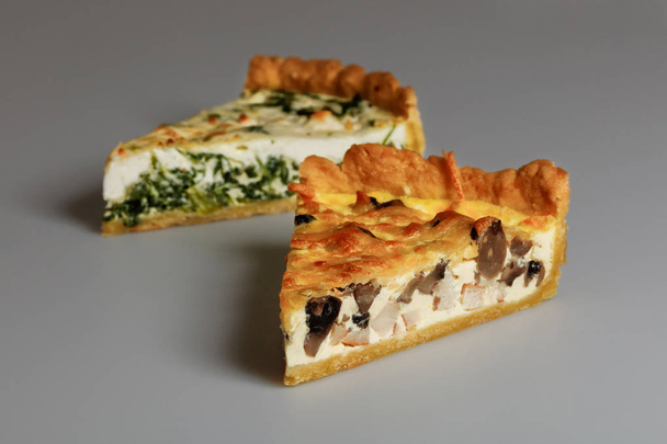 Two slices of spinach and chicken pies isolated on gray - Photo, Image
