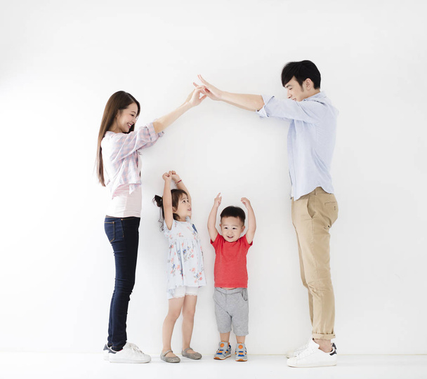 happy family making the home sign  before white wall - Foto, Imagem
