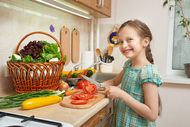дівчина рубає помідори, овочі та свіжі фрукти в інтер'єрі кухні, концепція здорової їжі
 - Фото, зображення