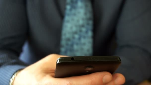 Lähikuva liikemies selailu viestejä hänen viimeisen sukupolven älypuhelin
. - Materiaali, video