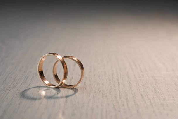 Два обручальных кольца на деревянном фоне
 - Фото, изображение