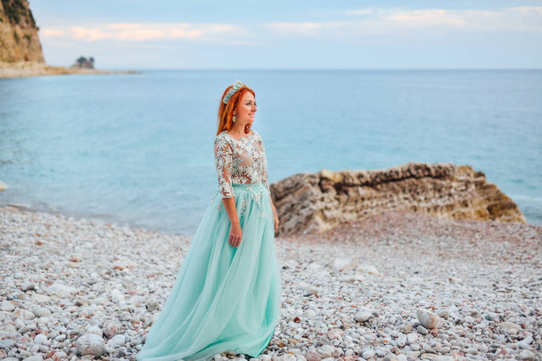 young woman in a luxurious dress stands on the shore of the Adriatic Sea - Foto, Bild