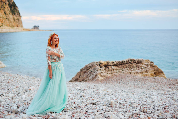 young woman in a luxurious dress stands on the shore of the Adriatic Sea - Foto, Bild