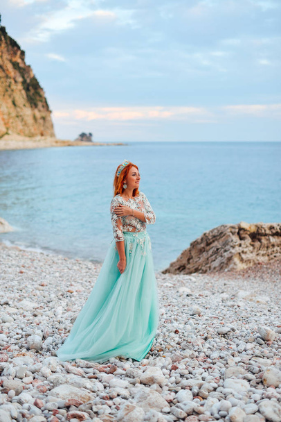 junge Frau in luxuriösem Kleid steht am Ufer der Adria - Foto, Bild