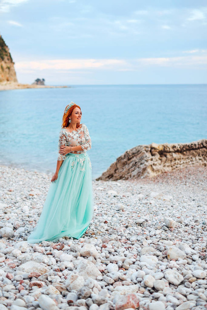 young woman in a luxurious dress stands on the shore of the Adriatic Sea - Foto, Imagen