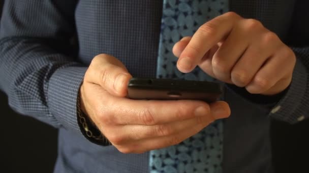 Крупним планом на бізнесмен переглядає повідомлення на своєму смартфоні останнього покоління
. - Кадри, відео