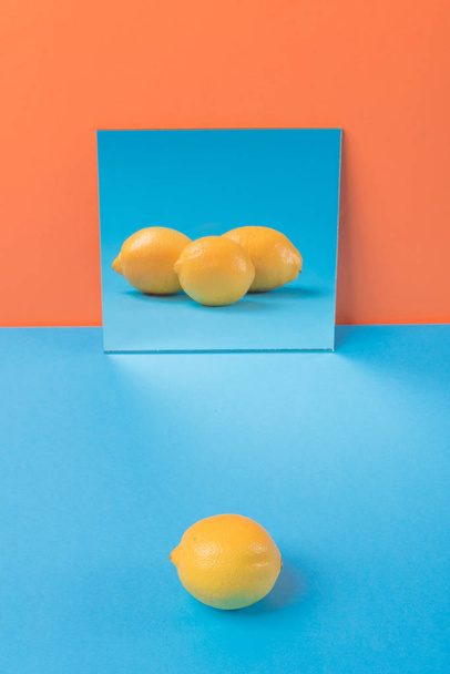 Lemon on blue table isolated over orange background - Foto, Imagem