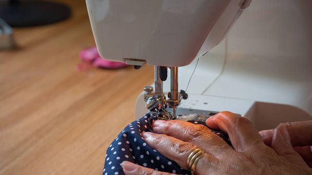 mano femenina usando máquina de coser costura fabic
 - Foto, Imagen
