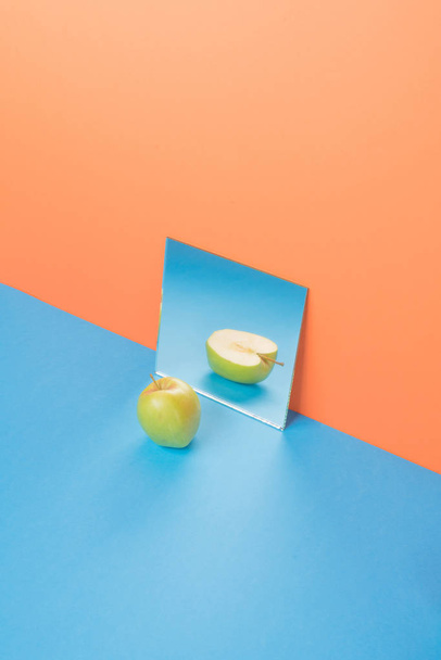 Apple on blue table isolated over orange background - Photo, Image