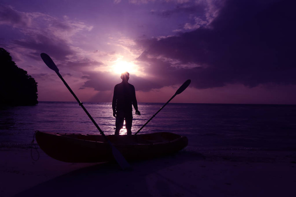 Silhouette Kajak fahren am Strand mit Mann Blick auf Sonnenuntergang. - Foto, Bild