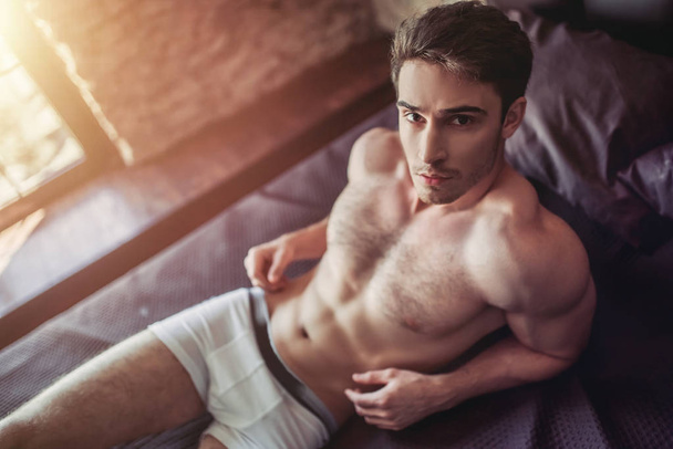 Handsome man on bed - Photo, Image