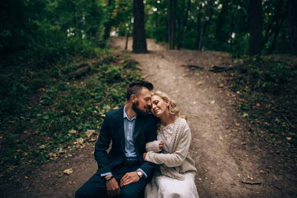 wife hugging husband while sitting on stub - Valokuva, kuva