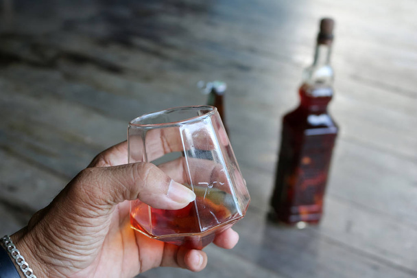 Whisky local en un vaso con botella de licor de hierbas
. - Foto, Imagen