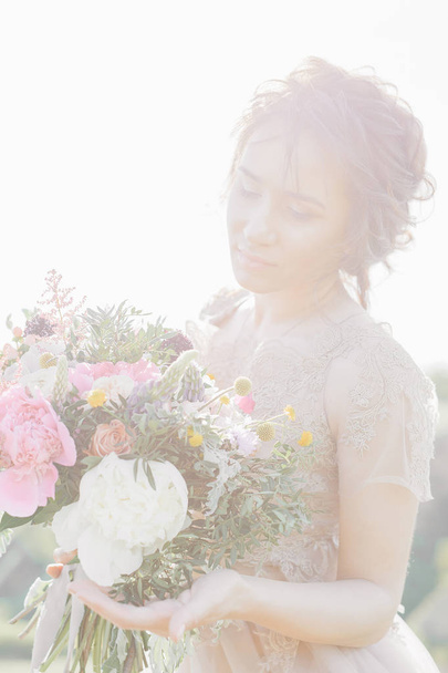 Portrait of beautiful bride with bouquet in nature. fine art photography. - Фото, изображение