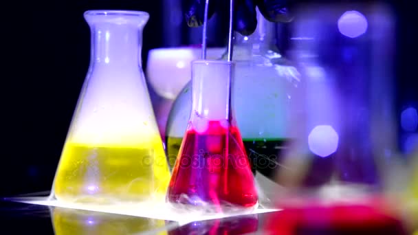 Chemické varné baňky s pestrobarevným kapaliny - Záběry, video