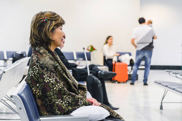 Femme en attente assise dans le salon de départ de l'aéroport
 - Photo, image