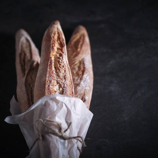 Drie vers gebakken stokbrood op tafel. - Foto, afbeelding